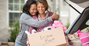 African American mother helping daughter pack for college
