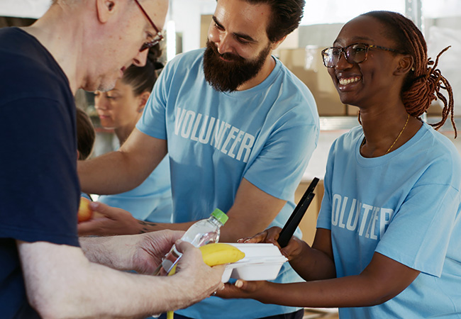 group of volunteers serving food at homeless shelter